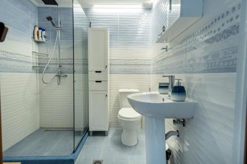 a white bathroom with a sink and a toilet at Vitamine Sea in Alexandroupoli