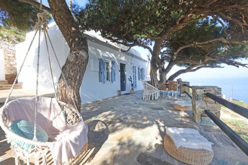 a swing hanging from a tree in front of a house at Thealos view in Ermoupoli
