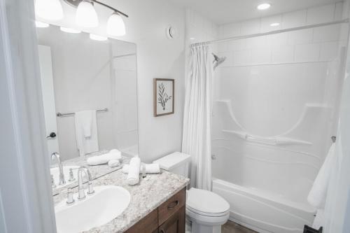 ein weißes Badezimmer mit Waschbecken und Toilette in der Unterkunft DOWNTOWN KINGBED 4Br FIREPLACE BIKELANE in Edmonton