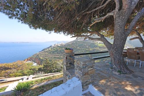 a house with a tree and the view of the ocean at Thealos view in Ermoupoli
