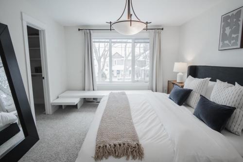 ein Schlafzimmer mit einem großen weißen Bett und einem Fenster in der Unterkunft DOWNTOWN KINGBED 4Br FIREPLACE BIKELANE in Edmonton