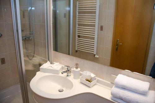 a bathroom with a sink and a shower and a mirror at Hotel Enztal Garni in Bietigheim-Bissingen