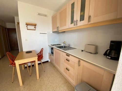 une petite cuisine avec une table et un évier dans l'établissement Appartement 19m² avec Balcon, Proche Thermes et Etang de Thau - Parking Public - Animaux Admis - FR-1-503-46, à Balaruc-les-Bains