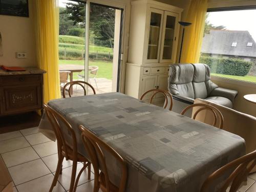 une salle à manger avec une table et des chaises et une fenêtre dans l'établissement Maison face à la mer, à Erquy