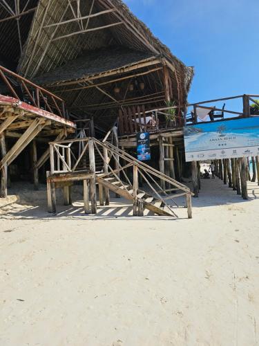 a building on the beach with a person standing in it at ZanziBalkan House Nungwi in Nungwi