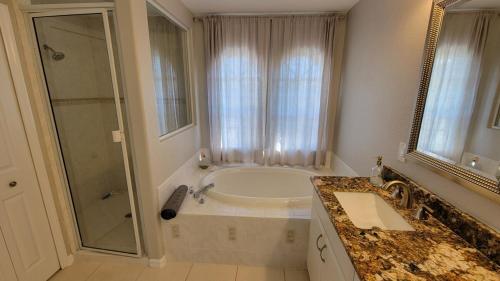 ein Badezimmer mit Badewanne, Dusche und Waschbecken in der Unterkunft SW Florida Waterfront Home in Cape Coral
