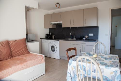 un salon avec une table et une cuisine dans l'établissement Au coeur de ville - à proximité de tout, à Pornichet