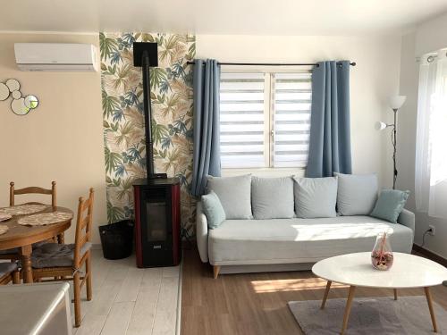 a living room with a couch and a table at Le petit coin de la Haute Somme in Hem-Monacu