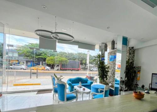 a living room with blue chairs and a table at Mar Inn Hotel in Ríohacha