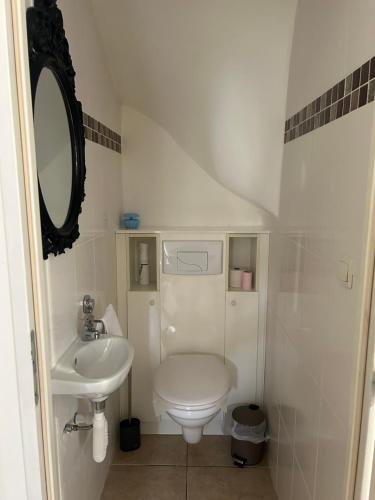 a white bathroom with a sink and a toilet at Au petit bonheur in Gorze