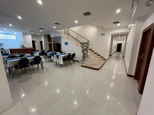 a dining room with tables and chairs and a staircase at Mar Inn Hotel in Ríohacha