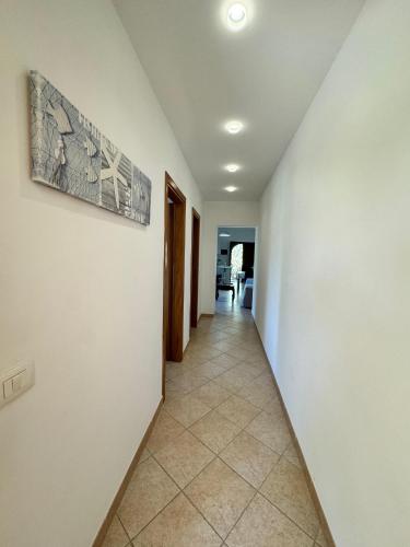 a hallway with white walls and a tile floor at Mare Apartment 4 in Scalea