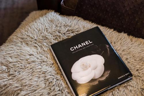 a book with a white flower sitting on a couch at Artesana - Privately Owned Rosewood Residence in San Miguel de Allende