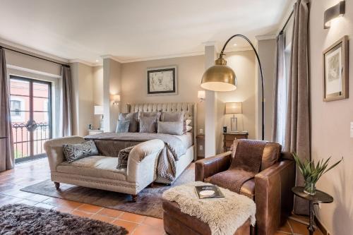 a bedroom with a bed and a couch and a chair at Artesana - Privately Owned Rosewood Residence in San Miguel de Allende