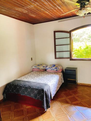 a bedroom with a bed and a window at Sítio Pand'Oro in Atibaia