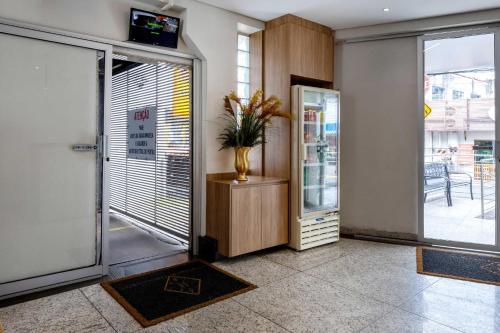 a lobby with a door with a vase of flowers at Contagem Centro Hotel in Contagem
