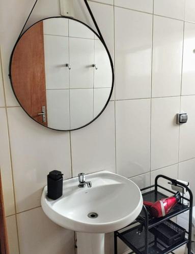 a bathroom with a white sink and a mirror at Básico & Aconchegante in Itajubá