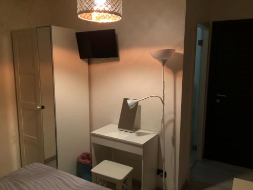 ein Schlafzimmer mit einer Lampe und einem Computer auf einer Kommode in der Unterkunft B&B Massimo Centro in Catania