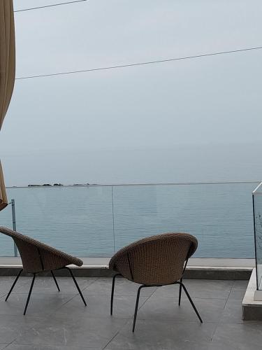 two chairs sitting in front of a view of the ocean at Galazio Seaside Luxury Rooms & Coffee Shop in Platamonas
