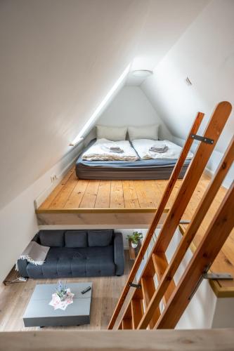 a room with a bed and a couch under a staircase at Villa Backstein OBO19 in Schwerin