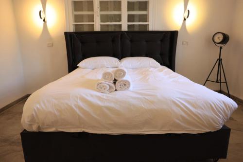 a bed with two rolls of towels on it at נוף במגדל in Migdal