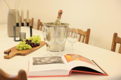 a book on a table with a bottle of wine and wine glasses at נוף במגדל in Migdal