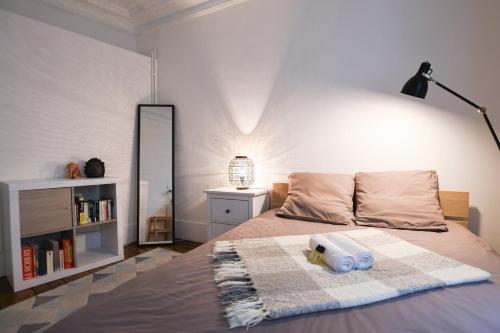 - une chambre avec un lit, une couverture et un miroir dans l'établissement GuestReady - Charm an Comfort in Épinettes, à Paris