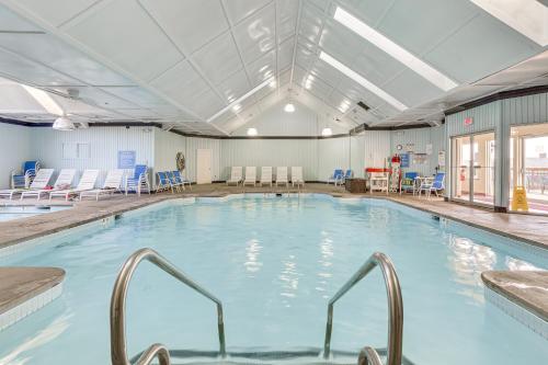 a large indoor swimming pool with blue chairs at Pocono Mountain Family Home with Deck and Grill in Saw Creek