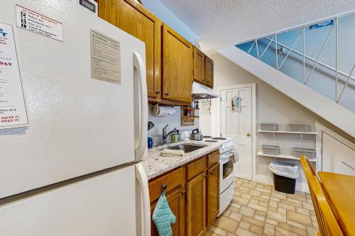a kitchen with white appliances and wooden cabinets at 1 Bed 1 Bath Vacation home in Newry in Newry