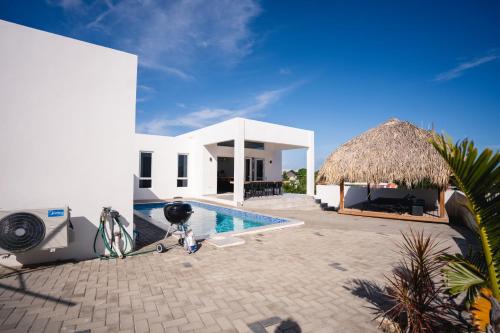 a villa with a swimming pool and a house at 'Casa 30' Villa nearby Mambo-Beach in Willemstad