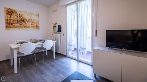 a living room with a table with chairs and a television at Italianway - Leonardo Da Vinci 135 in Udine