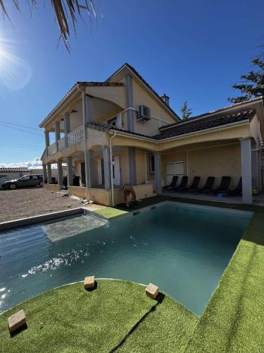 une maison avec une piscine devant une maison dans l'établissement Villa contemporaine avec piscine, à Romans-sur-Isère