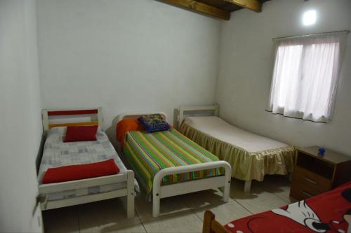 a small room with two beds and a window at Casa con Piscina y Parrilla in Timbues