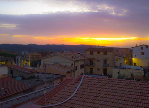 a sunset over the roofs of a town with buildings at La casa di Belle in Castelchiodato