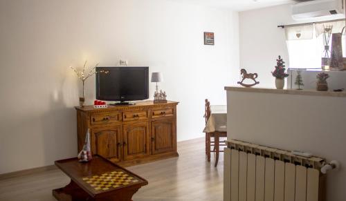 a living room with a tv on a wooden cabinet at La casa di Belle in Castelchiodato
