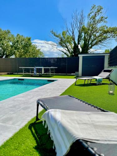 - une piscine avec une table et un banc à côté dans l'établissement La Charmésienne - Modern villa with pool, à Charmes-sur-Rhône