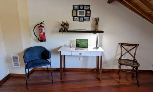 a desk with a laptop and a chair in a room at Casa da Tia Luísa in Furnas