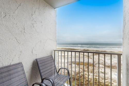 two chairs sitting on a balcony overlooking the beach at Plantation Dunes #5404 in Gulf Highlands