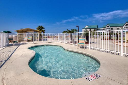 a swimming pool with a fence and chairs at Plantation Dunes #5404 in Gulf Highlands