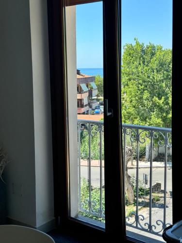 a door to a balcony with a view of the ocean at Mare Apartment 4 in Scalea