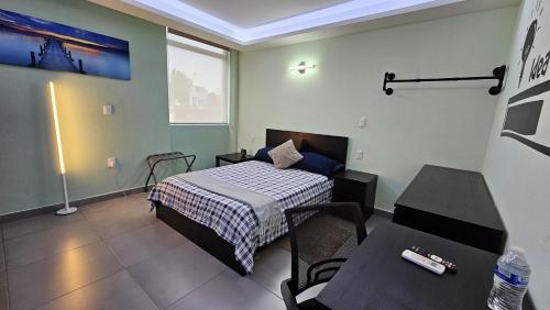 a bedroom with a bed and a table in it at A15 SUITE BLACK para 1 a 2 personas, Especialistas en CORTAS, MEDIANAS Y LARGAS ESTANCIAS en IZCALLI TEPOTZOTLAN perfecto para Familias, Turistas, Contratistas, Estudiantes, Empresas A sólo 5 min Izcalli 5 min Esmeralda 20 min Satélite 25 min AIFA in Cuautitlán Izcalli