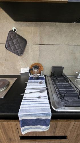 a kitchen counter with a stove with a towel on it at A15 SUITE BLACK para 1 a 2 personas, Especialistas en CORTAS, MEDIANAS Y LARGAS ESTANCIAS en IZCALLI TEPOTZOTLAN perfecto para Familias, Turistas, Contratistas, Estudiantes, Empresas A sólo 5 min Izcalli 5 min Esmeralda 20 min Satélite 25 min AIFA in Cuautitlán Izcalli