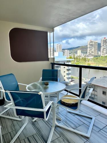 a balcony with a table and chairs and a view at Renovated Studio Free Parking in Prime Waikiki in Honolulu