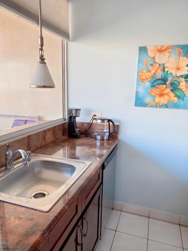 a kitchen counter with a sink and a mirror at Renovated Studio Free Parking in Prime Waikiki in Honolulu