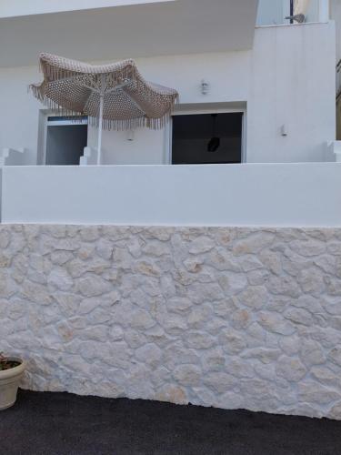 a white counter with a stone wall at Galazio Seaside Luxury Rooms & Coffee Shop in Platamonas