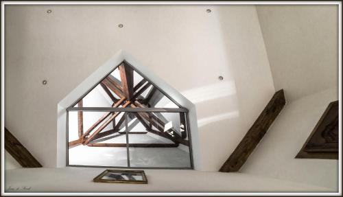 a room with a pyramid shaped window in a ceiling at Chambre d'Hôtes Bastide du Cosset in Barcelonne-du-Gers