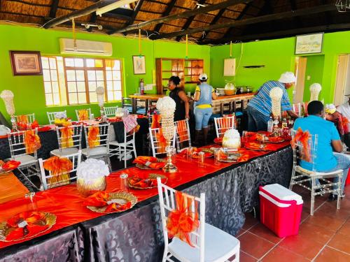 a group of people standing around a table in a room at Signature Guesthouse in Ventersburg