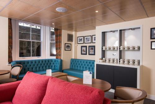 a waiting room with a couch and tables and chairs at Rewley House University of Oxford in Oxford