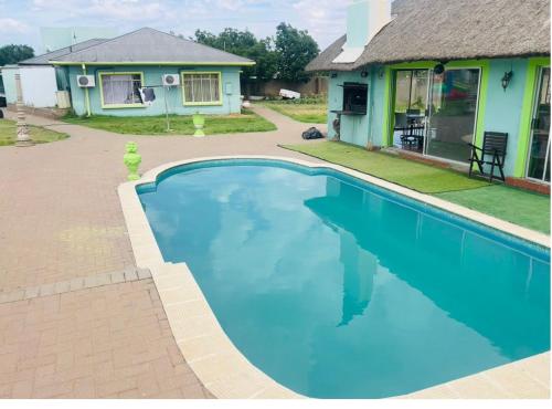 a swimming pool in front of a house at Signature Guesthouse in Ventersburg