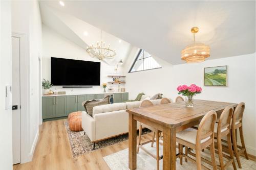 a dining room with a table and a couch at Luxe Designer Flat on Sloans Lake with Rooftop Deck in Denver